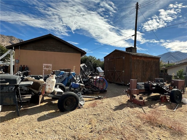 view of side of home featuring a mountain view and a storage shed