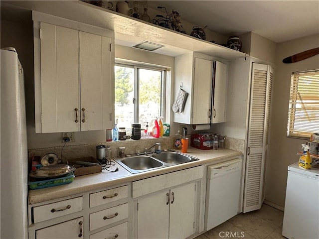 kitchen featuring sink, white cabinets, white appliances, and light tile patterned floors