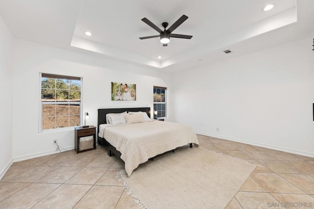 bedroom with a raised ceiling, ceiling fan, and light tile patterned floors