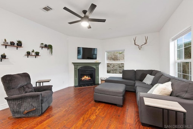 living room featuring a wealth of natural light, ceiling fan, and dark wood-type flooring