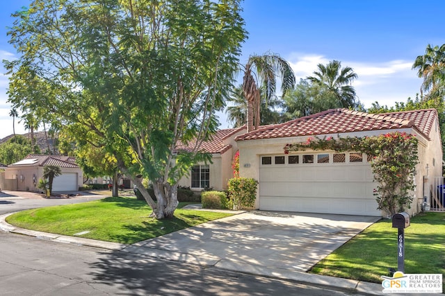 mediterranean / spanish house with a front lawn and a garage