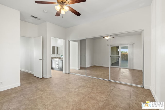 unfurnished bedroom with ceiling fan, light tile patterned floors, a closet, and sink