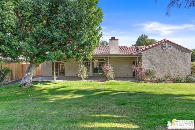 back of property with a yard and a patio