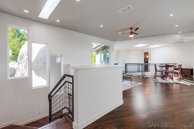 interior space with plenty of natural light, dark hardwood / wood-style flooring, and a skylight