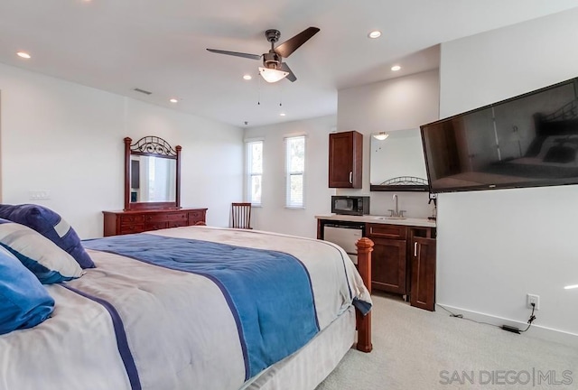 bedroom with ceiling fan, sink, and light carpet