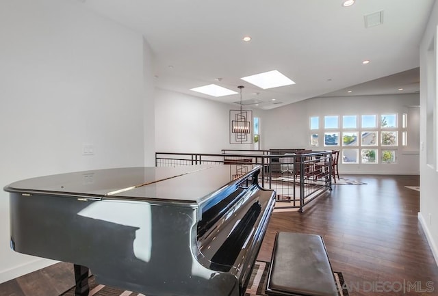 miscellaneous room with a skylight, dark hardwood / wood-style floors, and an inviting chandelier