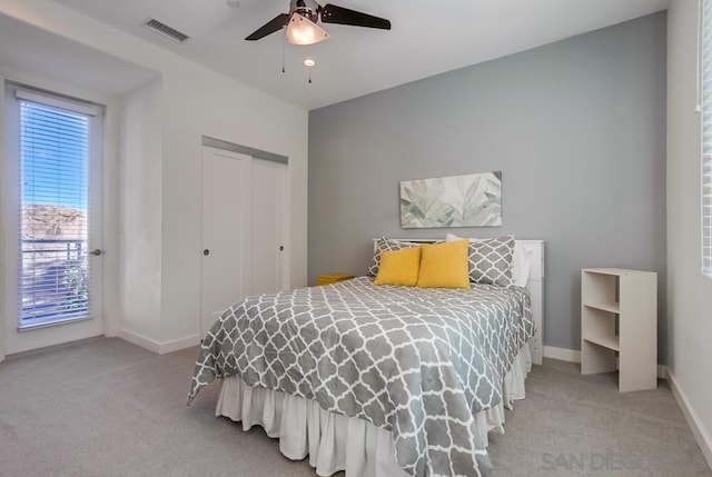 bedroom with ceiling fan, a closet, and light carpet