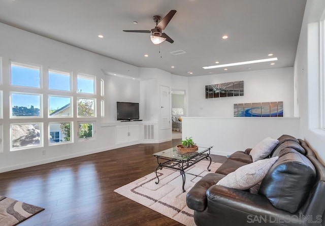 living room with ceiling fan and dark wood-type flooring