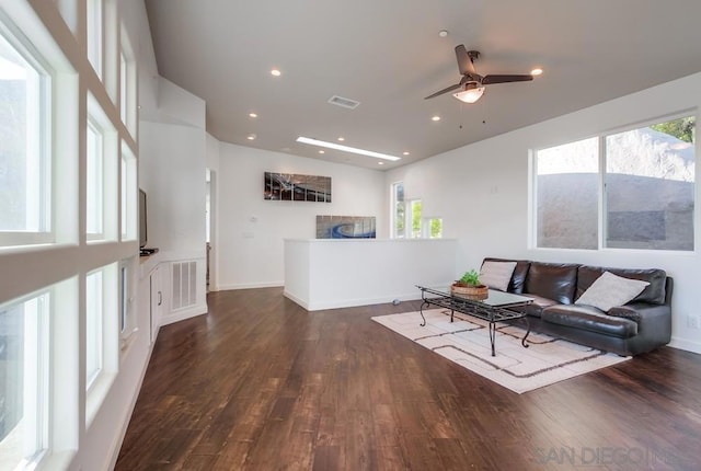 living room with ceiling fan and dark wood-type flooring