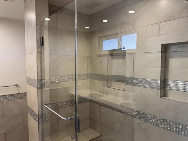 bathroom with a shower with door