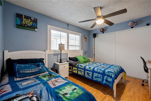 bedroom featuring a textured ceiling, light hardwood / wood-style flooring, and ceiling fan