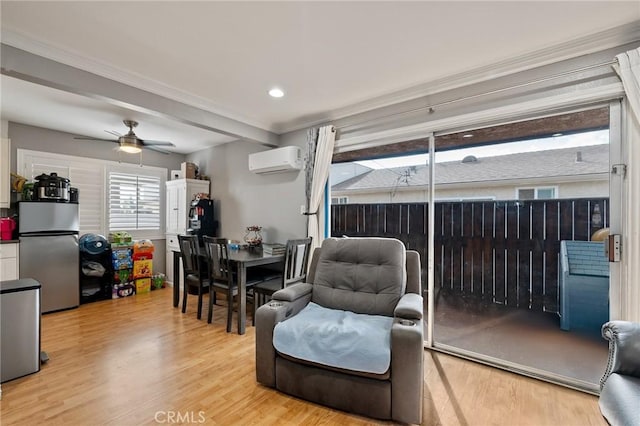 living room featuring ceiling fan, light wood-type flooring, crown molding, and a wall unit AC