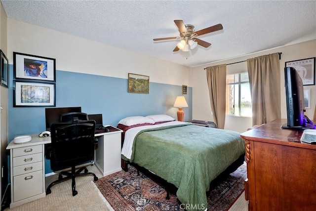 carpeted bedroom with ceiling fan and a textured ceiling