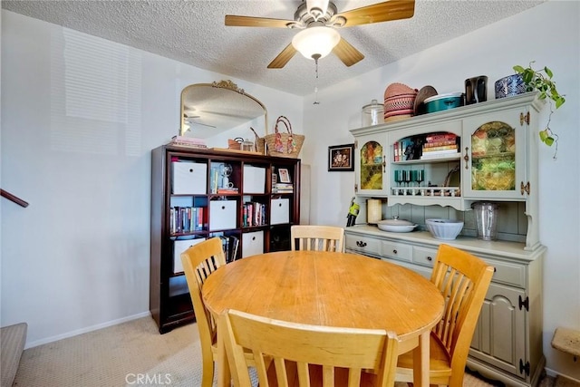 carpeted dining room with a textured ceiling