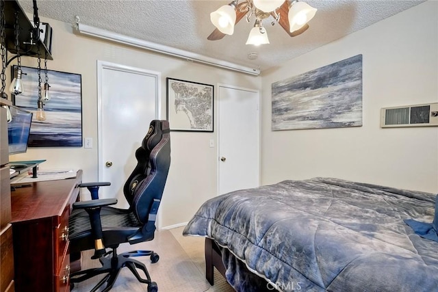 carpeted bedroom with ceiling fan, a textured ceiling, and a closet