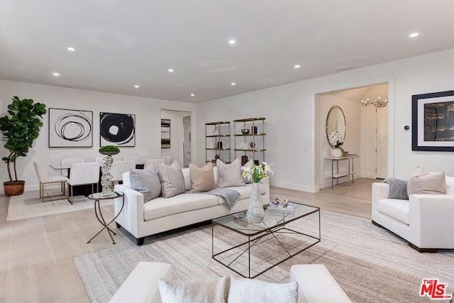 living room with light hardwood / wood-style floors and an inviting chandelier