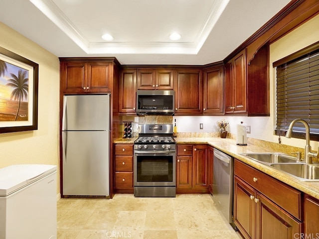 kitchen with light stone countertops, stainless steel appliances, a raised ceiling, and sink