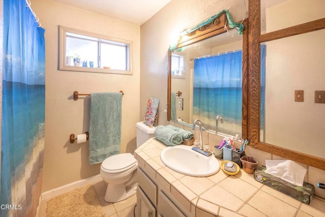 bathroom with tile patterned flooring, vanity, and toilet