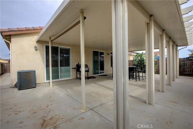 view of patio with central AC, a grill, and fence