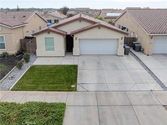 view of front facade with driveway, a tiled roof, an attached garage, and stucco siding