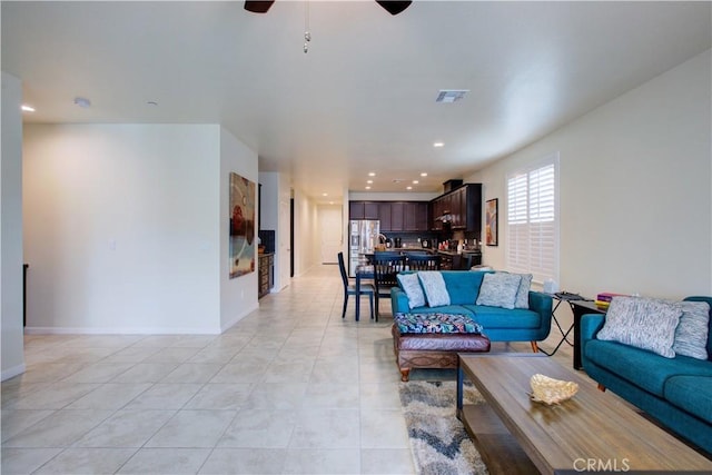 living area featuring light tile patterned floors, baseboards, visible vents, a ceiling fan, and recessed lighting