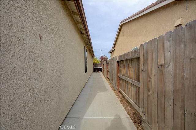 view of side of home with fence and stucco siding