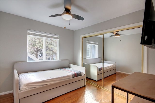 bedroom with ceiling fan, a closet, and hardwood / wood-style flooring