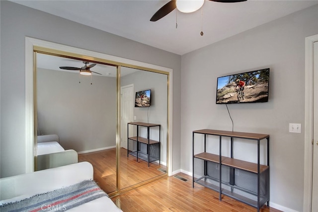 bedroom with ceiling fan, hardwood / wood-style flooring, and a closet