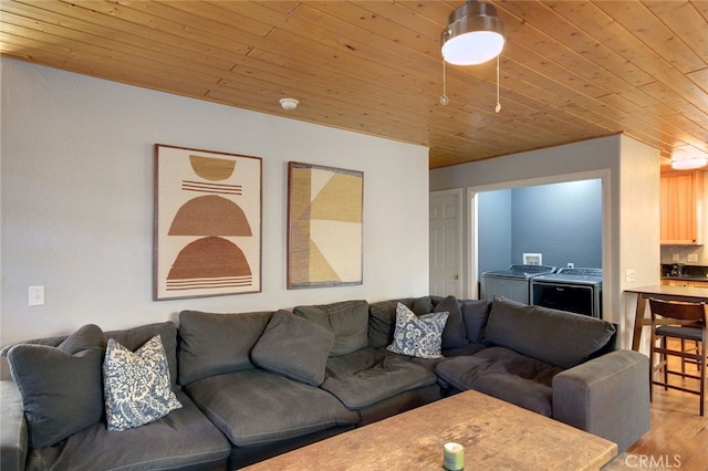 living room featuring wooden ceiling, wood-type flooring, and washing machine and clothes dryer