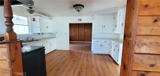 kitchen with light hardwood / wood-style flooring, white cabinets, and sink