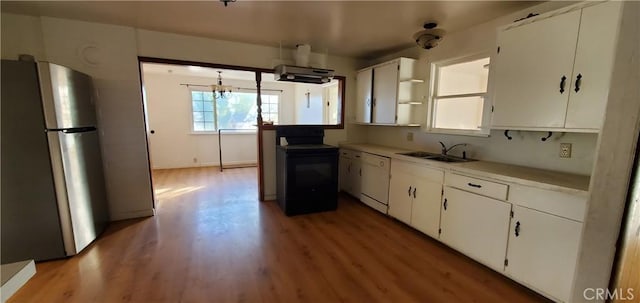 kitchen featuring white dishwasher, black range with electric stovetop, light hardwood / wood-style flooring, stainless steel fridge, and white cabinetry