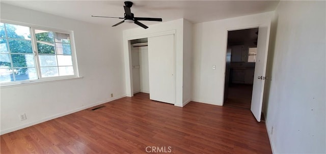 unfurnished bedroom featuring a closet, ceiling fan, and dark wood-type flooring