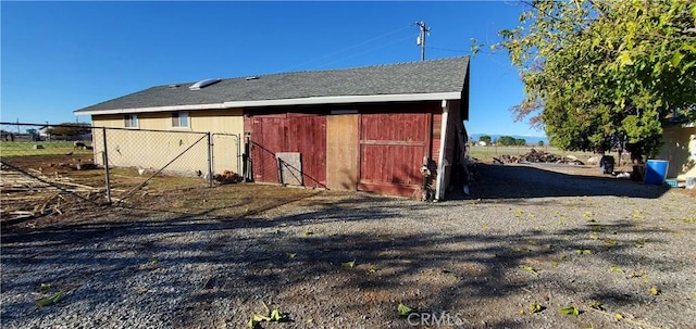 view of barn featuring fence