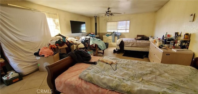 bedroom with ceiling fan and light tile patterned flooring