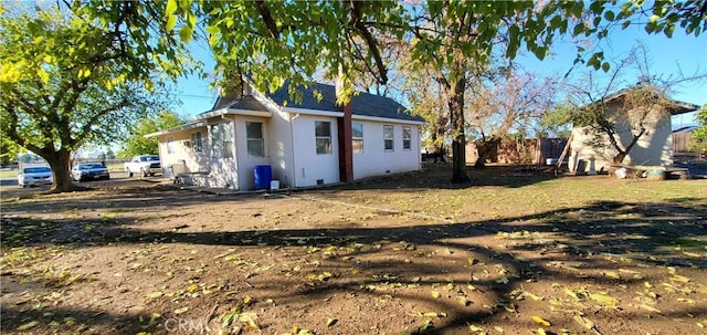 exterior space featuring stucco siding and fence