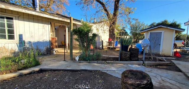 exterior space featuring an outdoor structure, a patio area, and a shed
