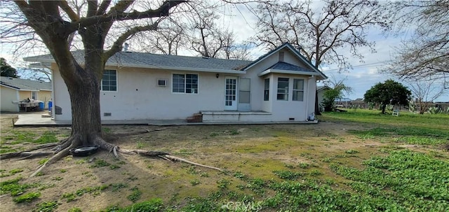 back of property with stucco siding and a patio