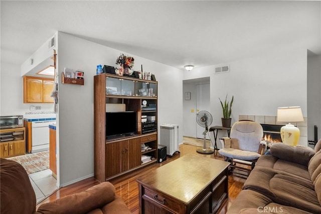 living room with light hardwood / wood-style floors, radiator heating unit, and a fireplace