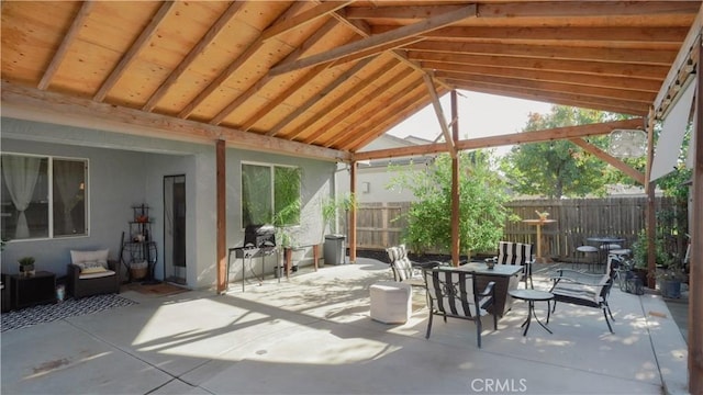 sunroom featuring a wealth of natural light and lofted ceiling with beams