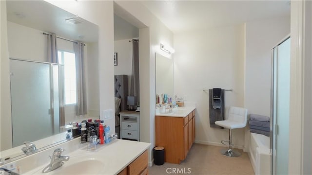 bathroom featuring a shower with door and vanity