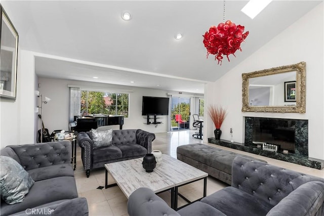 tiled living room with a fireplace and vaulted ceiling with skylight