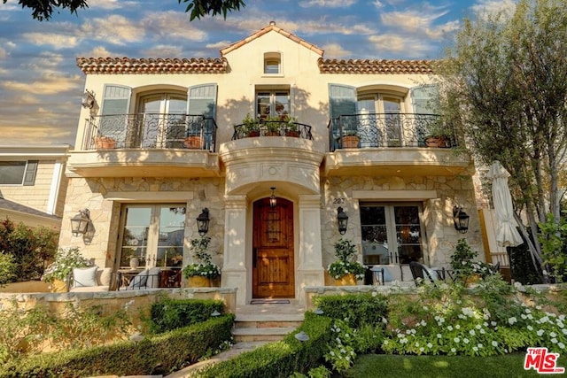 mediterranean / spanish house featuring a balcony