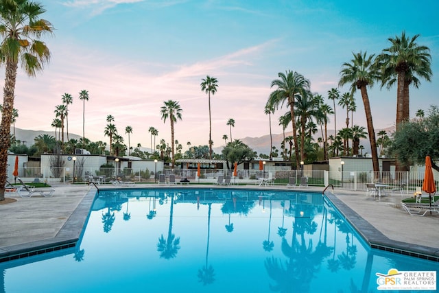 pool at dusk with a patio area