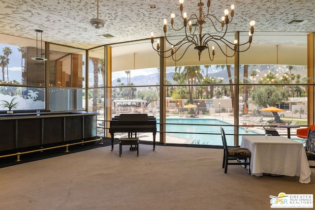 sunroom / solarium with a mountain view and a chandelier