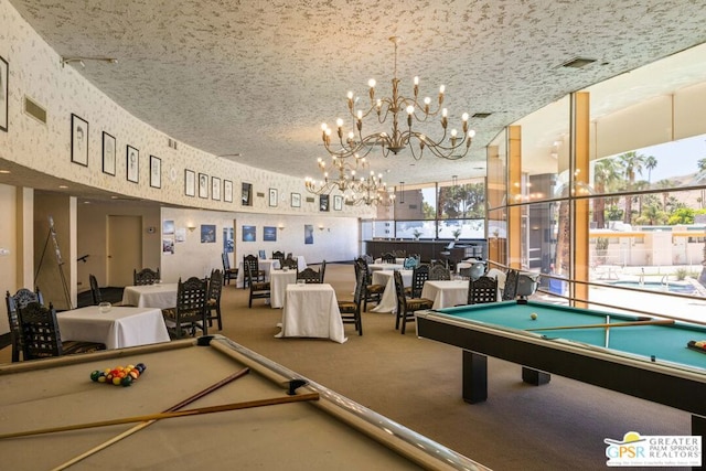 game room with an inviting chandelier, a wealth of natural light, pool table, and carpet flooring