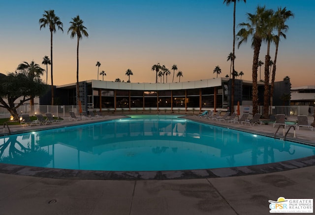 pool at dusk with a patio area