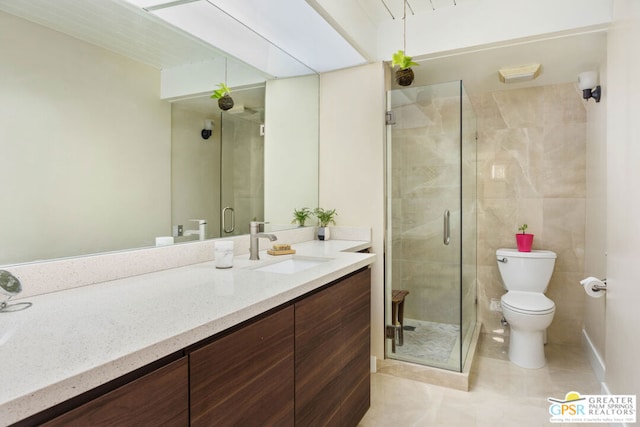 bathroom featuring toilet, vanity, tile patterned floors, and a shower with shower door