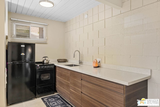 kitchen featuring sink, black appliances, and light tile patterned flooring