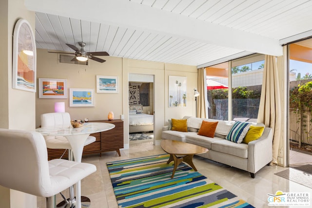 sunroom / solarium featuring beamed ceiling and ceiling fan