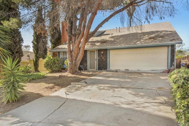 ranch-style home featuring an attached garage, driveway, and a shingled roof